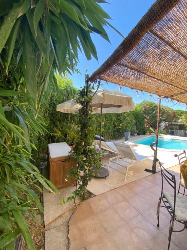 a patio with a table and chairs and a pool at La Papaline de Caroline in Saint-Saturnin-lès-Avignon