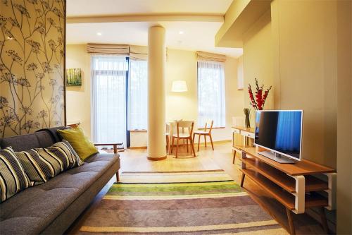 a living room with a couch and a flat screen tv at Ballare House in Druskininkai