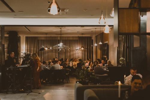 a crowd of people sitting at tables in a restaurant at Hotel President in Čapljina