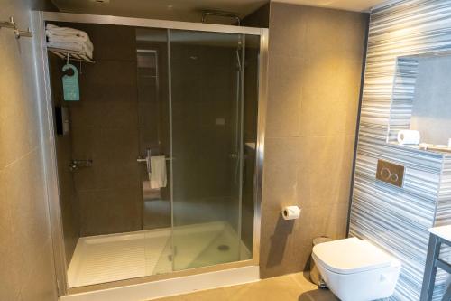 a bathroom with a shower and a toilet at Hotel Terrado Cavancha in Iquique