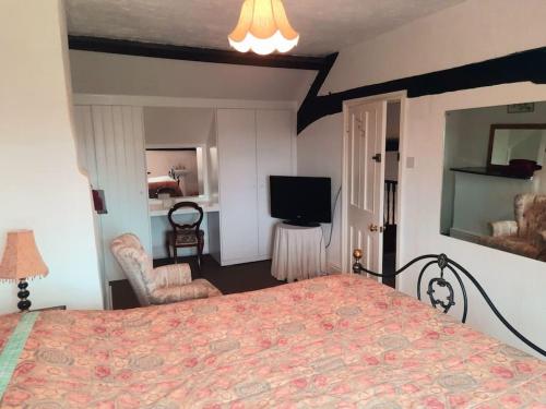 ein Schlafzimmer mit einem Bett und einem Flachbildfernseher in der Unterkunft 4 Bedroom Cottage in Wickwar, The Old Stables Guest House in Wickwar