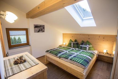 una camera con letto in legno e lucernario di Ferienwohnung Walder ad Außervillgraten
