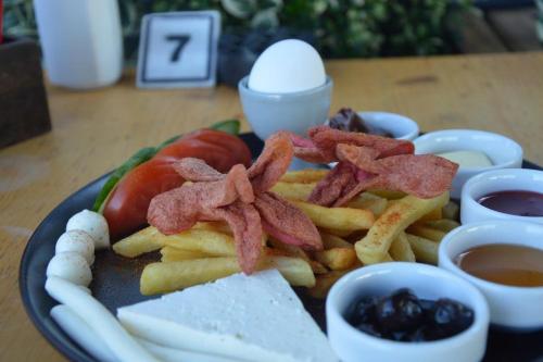 a plate of food with french fries and bacon at Yalı Bahçe Mudanya in Burgaz