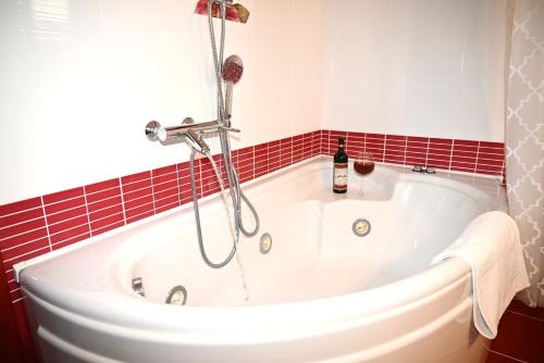 a white bath tub in a bathroom with red tiles at George Living House in Metsovo