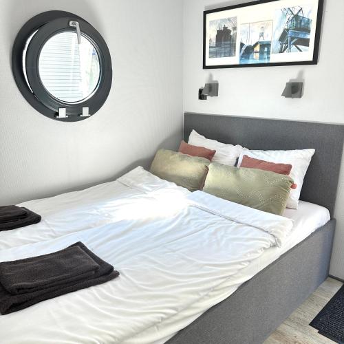 a bedroom with a large white bed with a mirror at La Mare Resort in Gothenburg