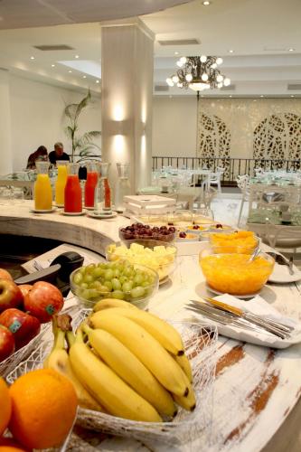 a buffet with bananas apples oranges and other fruits at Gardi Hotel & Suites in Buenos Aires