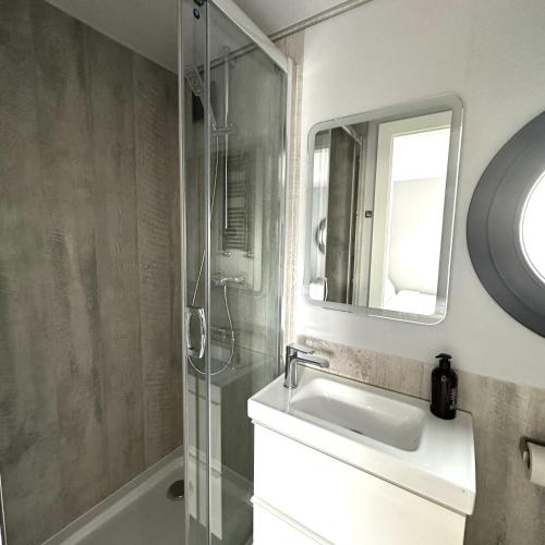 a bathroom with a shower and a sink and a mirror at La Mare Resort in Gothenburg