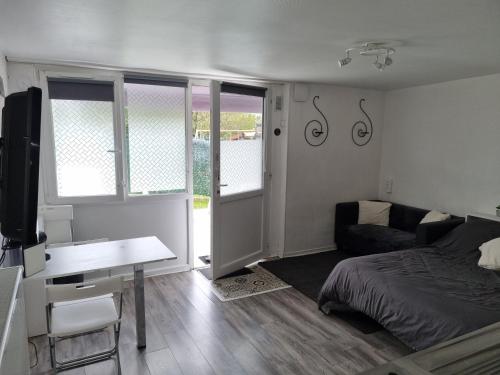 a bedroom with a bed and a desk with a desk at Jolie Maisonnette avec terrasse et jardin in Roissy-en-Brie