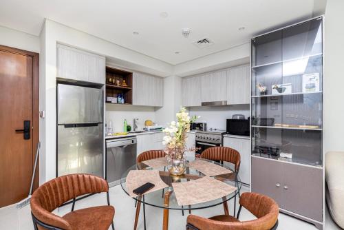 a kitchen with a glass table and chairs and a kitchen with a refrigerator at Luxury apartments at Vida Residences in Dubai