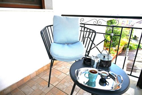 a table with a blue chair and a cup of coffee at George Living House in Metsovo