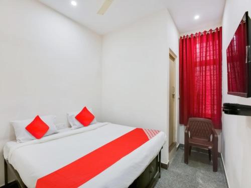 a bedroom with a bed and a red window at Manjushree Lodging in Bengaluru