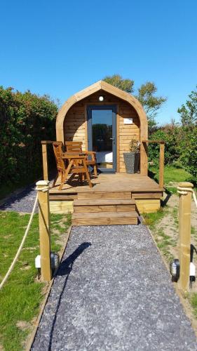 a wooden cabin with a table and a bench at Sea and Mountain Luxury Glamping Pods in Holyhead