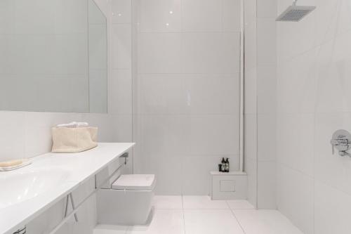 une salle de bain blanche avec un lavabo et une douche dans l'établissement Apt Dupleix Luxueux Cœur du 16ème 8P 4BR, à Paris