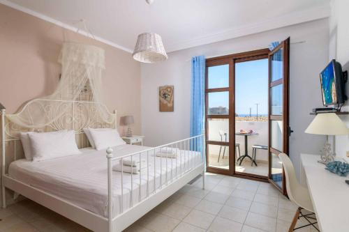 a bedroom with a white bed and a balcony at Lindos Sapphire in Lindos