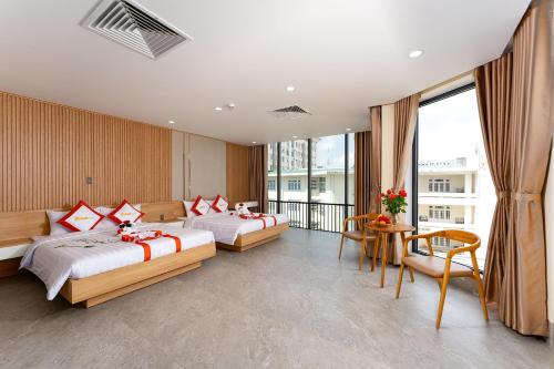 a hotel room with two beds and a balcony at DRAGON HUE HOTEL in Hue