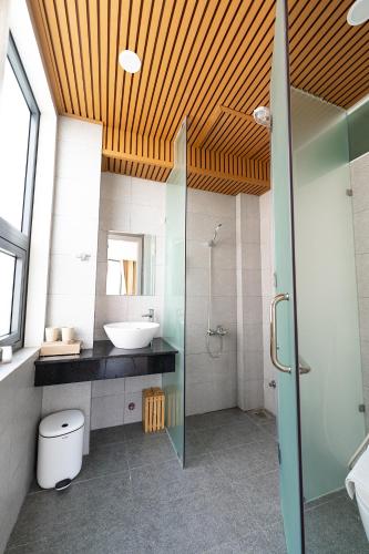 a bathroom with a sink and a toilet and a shower at DRAGON HUE HOTEL in Hue