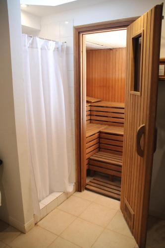 a walk in shower with a shower curtain in a bathroom at Gardi Hotel & Suites in Buenos Aires