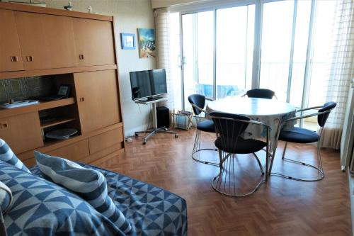 - un salon avec une table, des chaises et une télévision dans l'établissement Appartement VUE MER 4 personnes au centre de TREGASTEL - Ref 95, à Trégastel