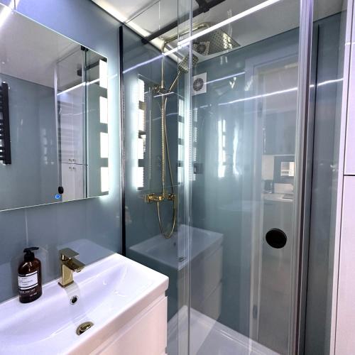 a bathroom with a glass shower and a sink at La Mare Resort in Gothenburg