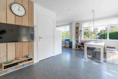 a living room with a large clock on a wall at Epelaan 34 in De Koog