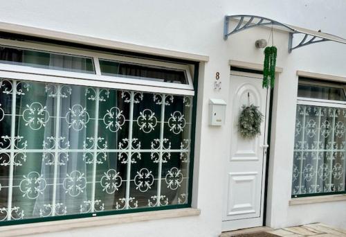 a door of a house with a green and white gate at Sweet Home - Praia das Rocas in Castanheira de Pêra