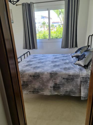 a bedroom with a bed and a window at bel appartement à louer in Cabo Negro