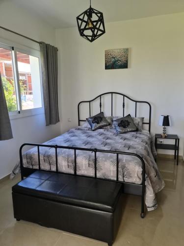 a bedroom with a bed with a black metal frame at bel appartement à louer in Cabo Negro