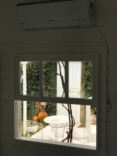 a window view of a patio with a table and chairs at CasaIvan in Florianópolis
