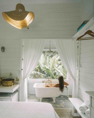a woman sitting in a bath tub in a bedroom at CasaIvan in Florianópolis