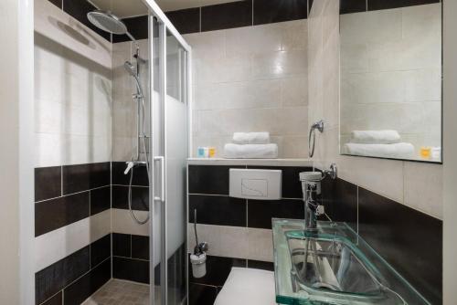 une salle de bain avec une douche en verre et un lavabo dans l'établissement Suite Antibes - Appartement à Antibes, à Antibes