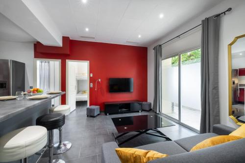 un salon avec un mur d'accent rouge dans l'établissement Suite Antibes - Appartement à Antibes, à Antibes