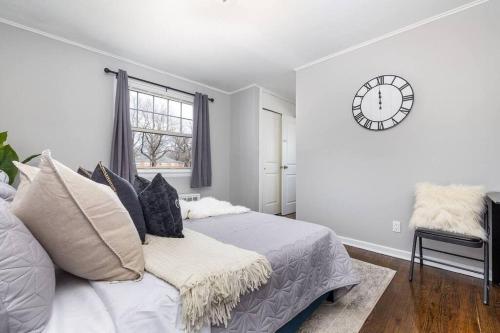 ein Schlafzimmer mit einem Bett und einer Uhr an der Wand in der Unterkunft Queen Bed Apt in West Hartford in West Hartford