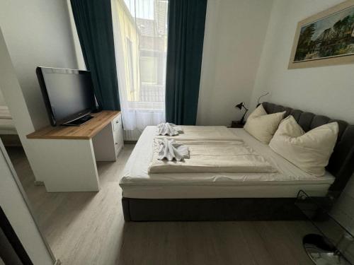 a small bedroom with a bed and a television at Hotel Drei Kronen in Dortmund
