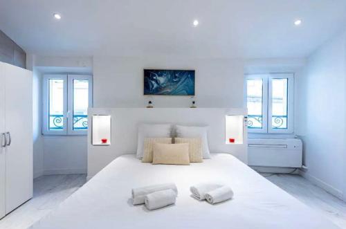- une chambre blanche avec un grand lit blanc et 2 serviettes dans l'établissement Suite Dali -Studio à Cannes, à Cannes