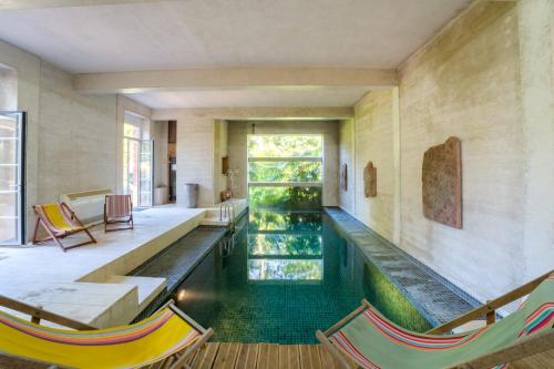 - une piscine au milieu d'une pièce avec des chaises dans l'établissement Château de Larunque, 15 p, piscine jacuzzi tennis - plages 30 mn, à Saint-Laurent-de-Gosse