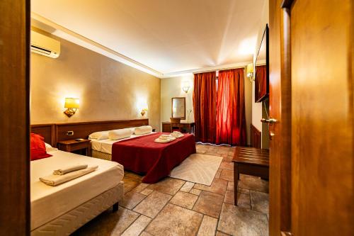 a hotel room with two beds and a red curtain at Malìa Home in Catania