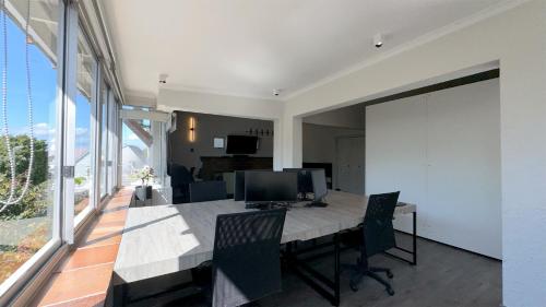 a dining room with a table with a computer on it at Anchor Bay Workation in Cape Town