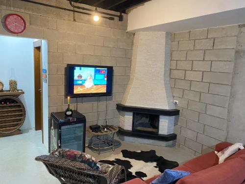 un soggiorno con camino e TV di Refugio do Capivari a Represa Capivari