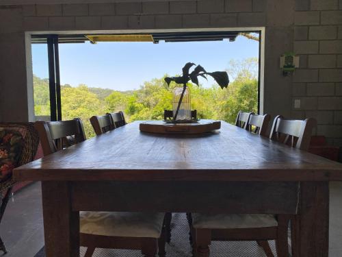 un grande tavolo in legno con sedie e una grande finestra di Refugio do Capivari a Represa Capivari