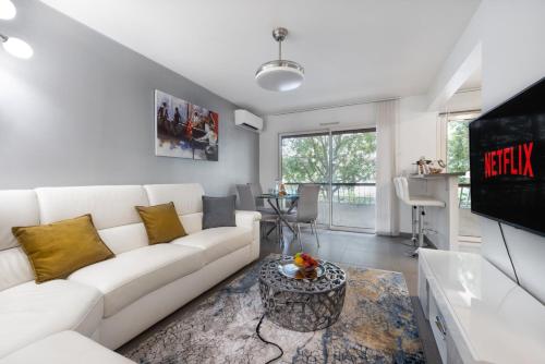 un salon avec un canapé blanc et une télévision dans l'établissement Suite Ioana - Appartement à Cannes, à Cannes