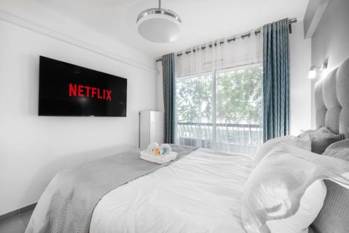 un lit blanc dans une chambre avec une fenêtre dans l'établissement Suite Ioana - Appartement à Cannes, à Cannes