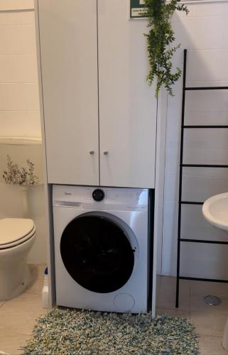 a washing machine in a bathroom next to a toilet at Sweet Home - Praia das Rocas in Castanheira de Pêra