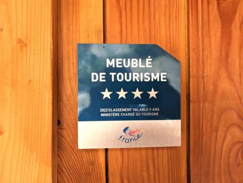 a sign hanging on a wooden wall with stars at La Boutame : chalet au pied des pistes à Villard Reculas in Villard-Reculas