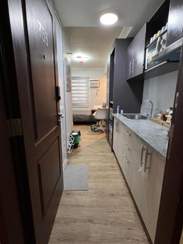 een kamer met een keuken met een deur en een gootsteen bij Fullerton Suites in Silang