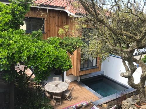 une arrière-cour avec une table et une piscine dans l'établissement Villa de la dune, à Seignosse