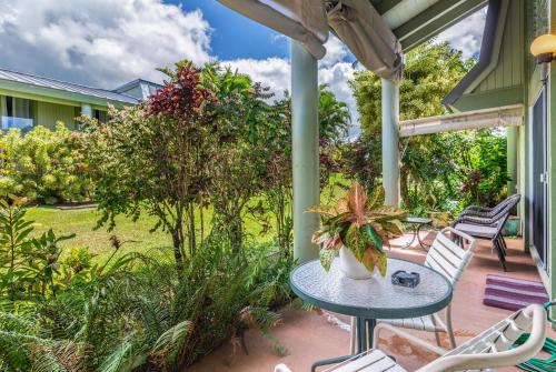 a patio with a table and chairs and plants at Puamana 9C in Princeville