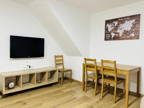 a living room with a table and a tv and chairs at Libertad B in Santiponce