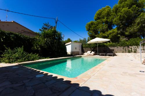 a swimming pool in a yard with an umbrella at INNOUTHOME Chalet familiar con piscina privada numero u in L'Ametlla de Mar