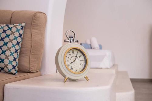 a clock sitting on a table next to a couch at Traditional Luxury House in Kalithies
