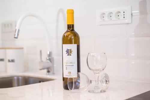a bottle of wine sitting next to two wine glasses at Traditional Luxury House in Kalithies